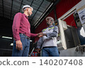 Business partnership handshake in industrial setting workshop environment professional meeting collaborative spirit 140207408