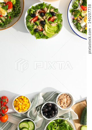 Several bowls of salad sit on a table with fresh toppings 140207738