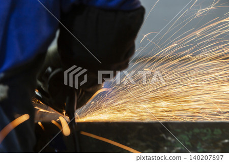 A scene of metal being ground with a grinder, with a large amount of sparks flying. A scene of metal being ground with a grinder, with a large amount of sparks flying. 140207897
