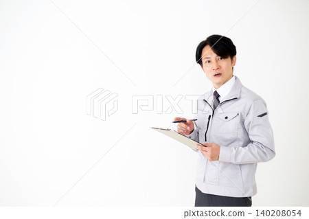 身穿灰色工作服的中年商人，手持一疊文件，背景為白色。 140208054