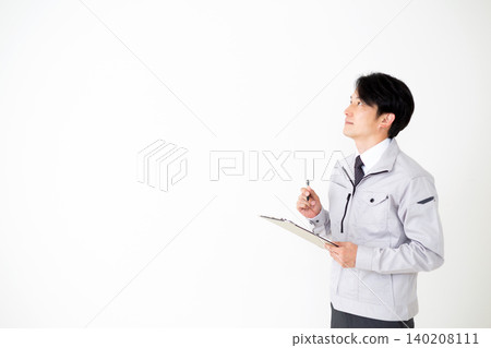 身穿灰色工作服的中年商人，手持一疊文件，背景為白色。 140208111