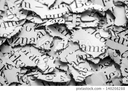 Scraps of paper with words and letters from magazines and newspapers. Newspaper paper strips background. 140208288