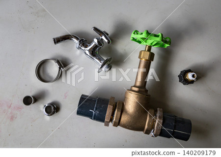 A flat tray displays plumbing components such as faucets, valves, and hose clamps. A flat tray displays plumbing components such as faucets, valves, and hose clamps. 140209179