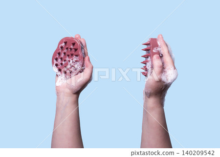 Pink silicone scalp massager in woman hand mockup. Hair brushing and massage. Isolated image for design Pink silicone scalp massager in woman hand mockup. Hair brushing and massage. Isolated image for design 140209542
