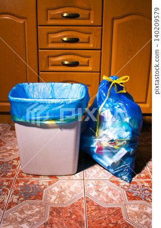 New trash bag in garbage bin and full trash bag on home kitchen New trash bag in garbage bin and full trash bag on home kitchen 140209579