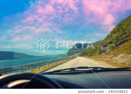 Mountain road along the fjord at sunset. View of the beautiful landscape from the windscreen. Nature of Norway 140209852