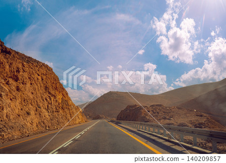 Driving a car on the mountain road in Israel. Desert landscape. Empty road. View from the car of mountain landscape with the striped sky. Israel 140209857