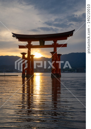 Famous red torii gate of Itsukushima shrine at sunset in Miyajima, Japan Famous red torii gate of Itsukushima shrine at sunset in Miyajima, Japan 140210010