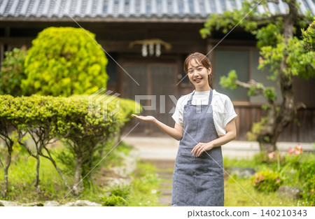 一位女工作人員正在帶領遊客參觀傳統的日式房屋。 140210343