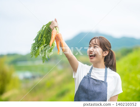 A smiling woman holding a carrot A smiling woman holding a carrot 140210352