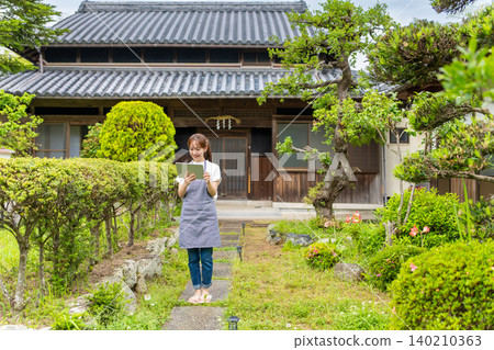 A woman holding a tablet in an old house 140210363
