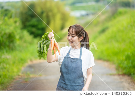 A woman holding freshly picked carrots 140210365