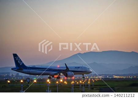 Sendai Airport at dusk, with a taxiing airplane and the Zao mountain range in the background, Natori City, Miyagi Prefecture. 140211212