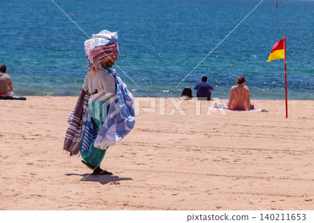 Beach Vendor Walking on Sandy Beach in Cascais Portugal Summer Beach Vendor Walking on Sandy Beach in Cascais Portugal Summer 140211653