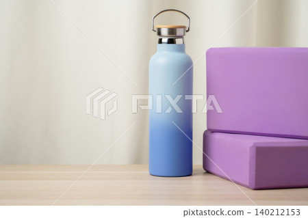 Reusable Water Bottle With Yoga Blocks on Wooden Table for Fitness, Yoga and Wellness Hydration Reusable Water Bottle With Yoga Blocks on Wooden Table for Fitness, Yoga and Wellness Hydration 140212153