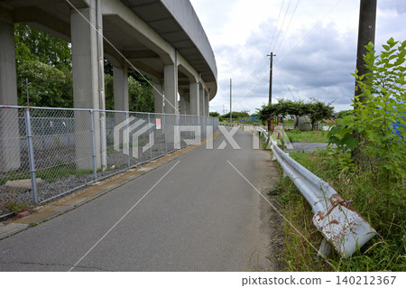 A rural residential road under an elevated structure. A rural residential road under an elevated structure. 140212367