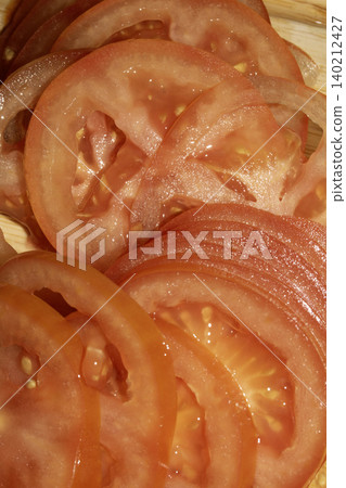 Close up of fresh tomato slices on wooden chopping board Close up of fresh tomato slices on wooden chopping board 140212427