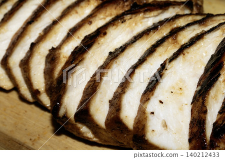 Close up of sliced roasted and glazed chicken breast on a wooden chopping board Close up of sliced roasted and glazed chicken breast on a wooden chopping board 140212433
