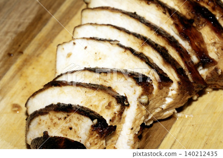 Close up of sliced roasted and glazed chicken breast on a wooden chopping board Close up of sliced roasted and glazed chicken breast on a wooden chopping board 140212435
