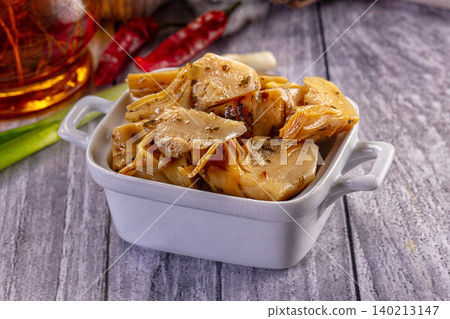 Marinated artichoke hearts in white ceramic dish with herbs and chili Marinated artichoke hearts in white ceramic dish with herbs and chili 140213147