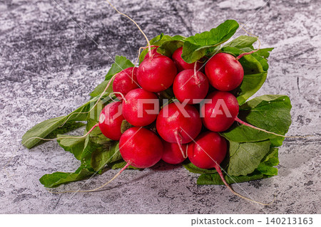 Fresh red radishes with green leaves on textured grey background Fresh red radishes with green leaves on textured grey background 140213163