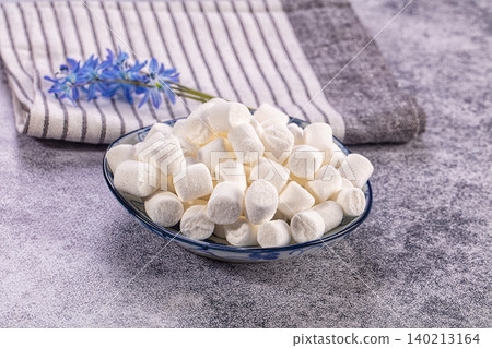 White mini marshmallows in ceramic bowl with striped napkin and blue flowers White mini marshmallows in ceramic bowl with striped napkin and blue flowers 140213164