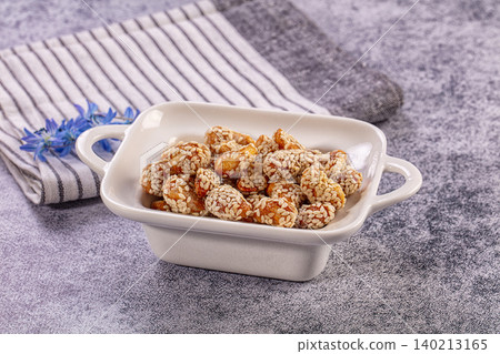 Sweet roasted peanuts coated in white sesame seeds, delicious crispy snack Sweet roasted peanuts coated in white sesame seeds, delicious crispy snack 140213165