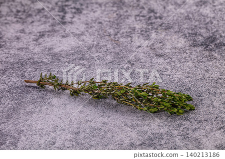 Fresh green thyme sprig on textured grey stone background Fresh green thyme sprig on textured grey stone background 140213186