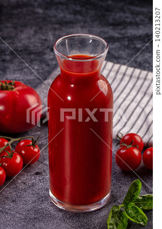 Fresh tomato juice in glass carafe with ripe tomatoes and basil Fresh tomato juice in glass carafe with ripe tomatoes and basil 140213207