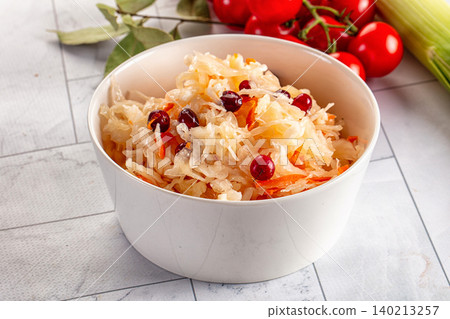 Fermented sour pickled sauerkraut cabbage with cranberries and carrots in white bowl Fermented sour pickled sauerkraut cabbage with cranberries and carrots in white bowl 140213257