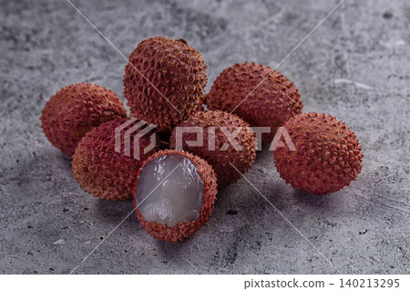 Fresh tropical lychee fruit with peeled flesh on stone background Fresh tropical lychee fruit with peeled flesh on stone background 140213295