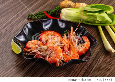 Steamed prawns in black bowl with fresh herbs and spices Steamed prawns in black bowl with fresh herbs and spices 140213351