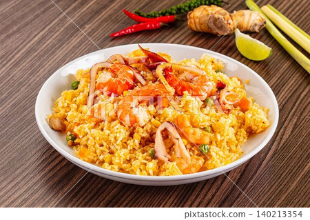 Flavorful Asian fried rice with succulent prawns, tender calamari, vibrant vegetables, and aromatic spices. Delicious seafood entree Flavorful Asian fried rice with succulent prawns, tender calamari, vibrant vegetables, and aromatic spices. Delicious seafood entree 140213354