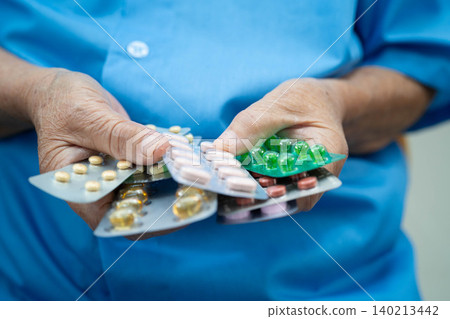 Asian elderly woman holding pill drug in hand, strong healthy medical concept. Asian elderly woman holding pill drug in hand, strong healthy medical concept. 140213442