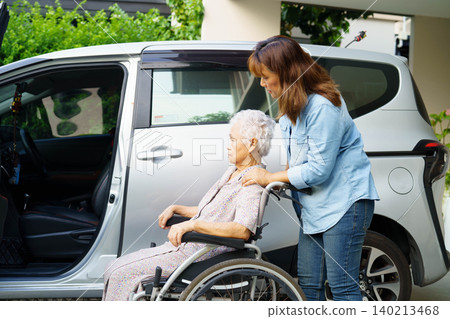 Caregiver help Asian elderly woman disability patient use wheelchair to get in car. Caregiver help Asian elderly woman disability patient use wheelchair to get in car. 140213468