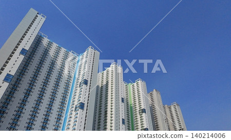 Low-angle view of modern high-rise residential apartment buildings against a blue sky Low-angle view of modern high-rise residential apartment buildings against a blue sky 140214006