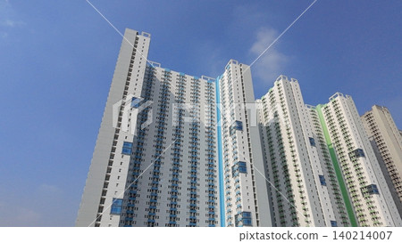 Low-angle view of modern high-rise residential apartment buildings against a blue sky Low-angle view of modern high-rise residential apartment buildings against a blue sky 140214007
