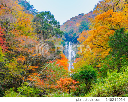 Kamba Falls at the peak of autumn foliage: A slow shutter speed captures the smooth flow of the magnificent waterfall and the serene autumn scenery, completely deserted. Kamba Falls at the peak of autumn foliage: A slow shutter speed captures the smooth flow of the magnificent waterfall and the serene autumn scenery, completely deserted. 140214034
