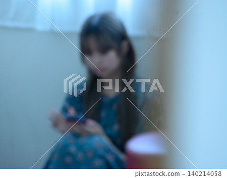 Young woman looking at a smartphone Young woman looking at a smartphone 140214058