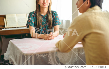 A man and a woman talking at a table 140214061