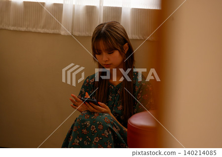 A woman watching a smartphone A woman watching a smartphone 140214085