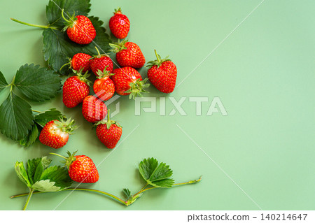 Fresh ripe strawberries with leaves on green background Fresh ripe strawberries with leaves on green background 140214647