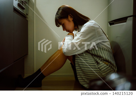 A woman sitting in the kitchen A woman sitting in the kitchen 140215120