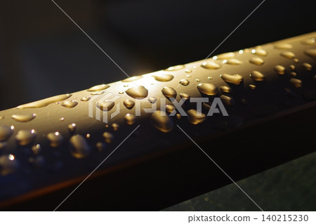 Raindrops on a railing in the light (from bottom left to top right) Raindrops on a railing in the light (from bottom left to top right) 140215230