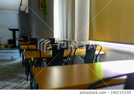 An empty classroom, light streaming in through the window 140215330