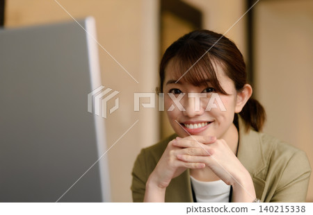 一個女人帶著微笑走向電腦 140215338