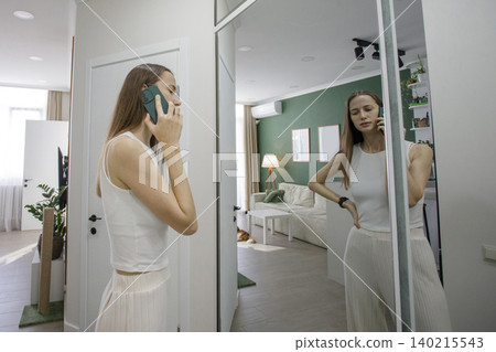 Portrait of woman talking with someone over the phone at home Portrait of woman talking with someone over the phone at home 140215543