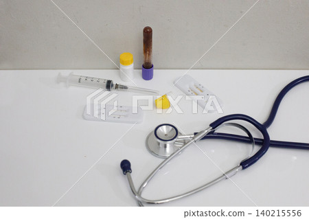 Medical supplies such as test kits, syringes, and a stethoscope are placed on a table Medical supplies such as test kits, syringes, and a stethoscope are placed on a table 140215556