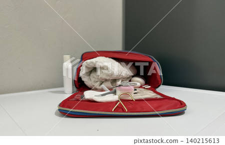 Tools and items in a red bag on a white table with various grooming Tools and items in a red bag on a white table with various grooming 140215613
