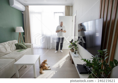 Handsome man texting on smartphone in living room for online mobile app, scroll social media Handsome man texting on smartphone in living room for online mobile app, scroll social media 140215621